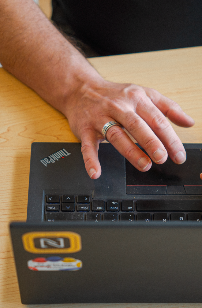 Mains de Bruno Joliveau qui travaille sur son ordinateur portable